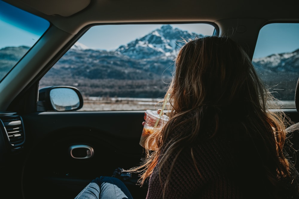 woman in black jacket driving car during daytime