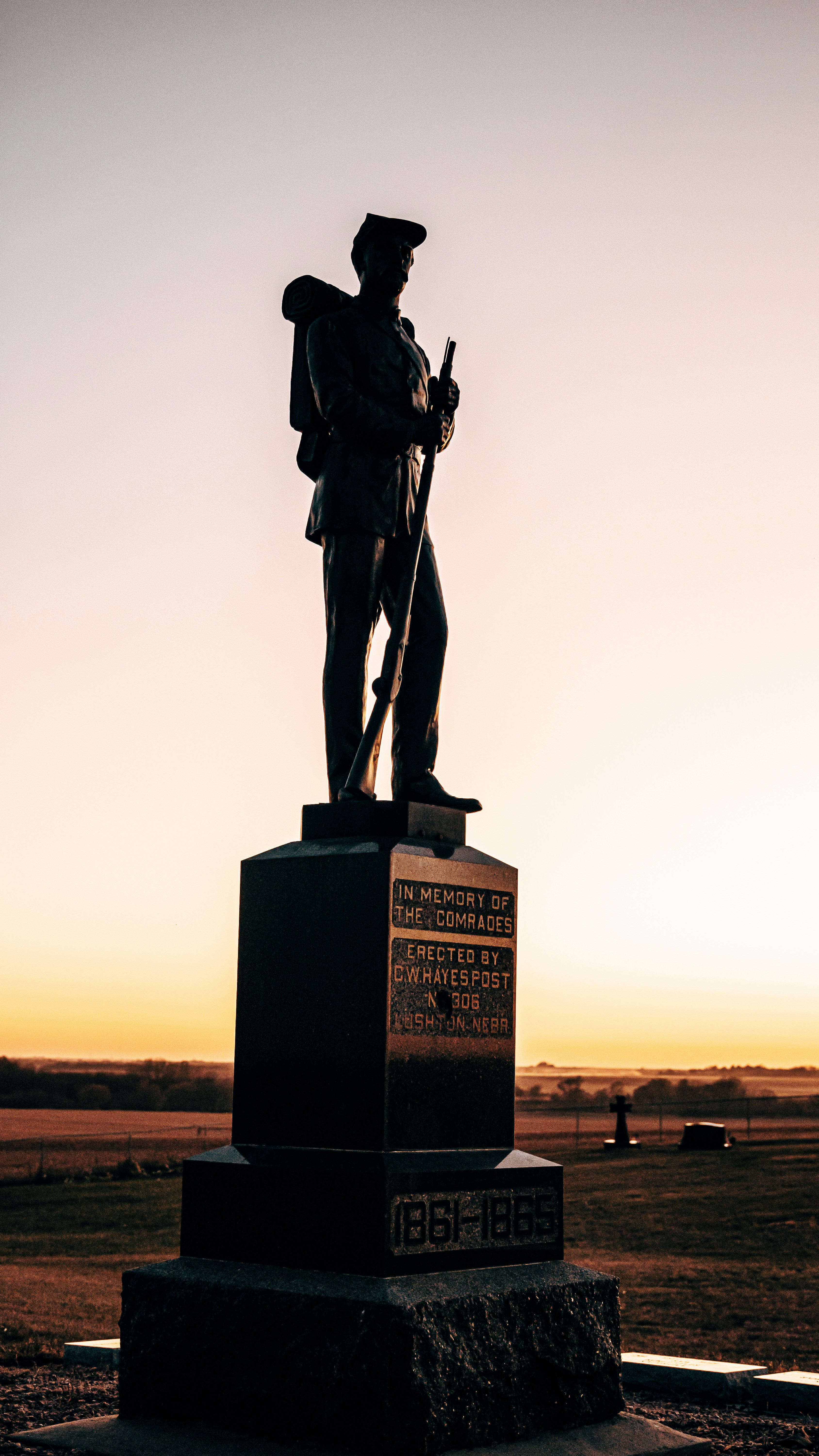 man holding rifle statue during daytime