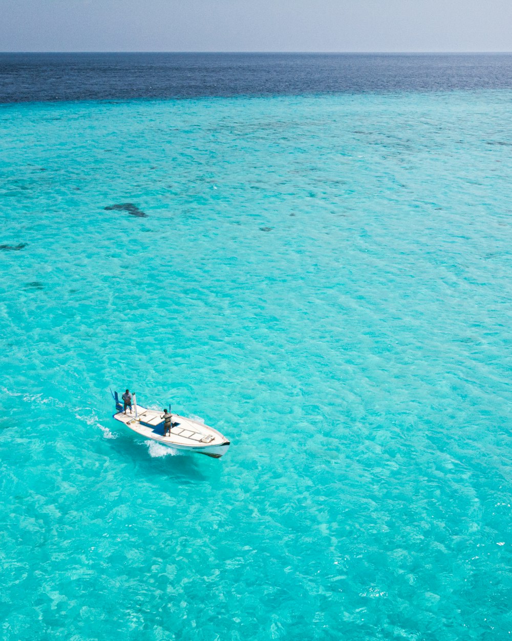 barca bianca e nera sul mare blu durante il giorno