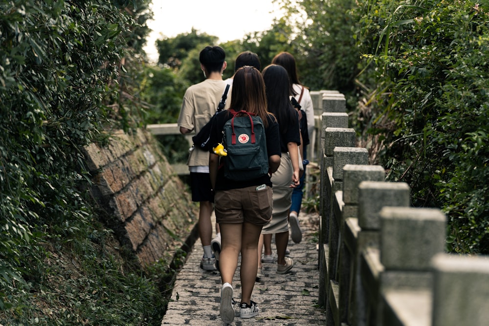 2 women walking on wooden bridge during daytime