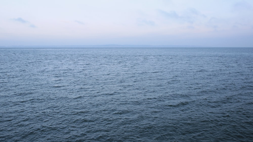 body of water under white sky during daytime