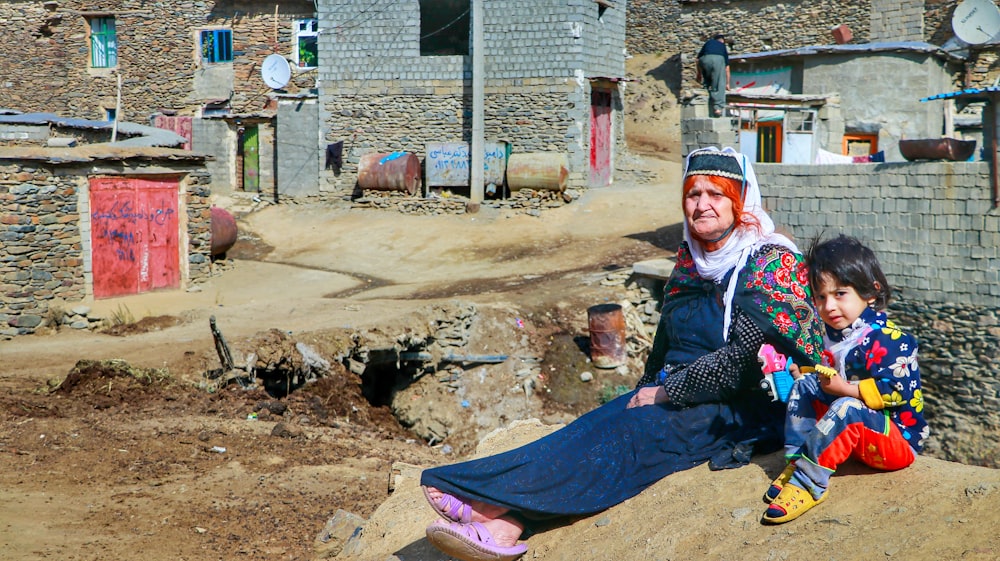 a man and a little girl sitting on a rock