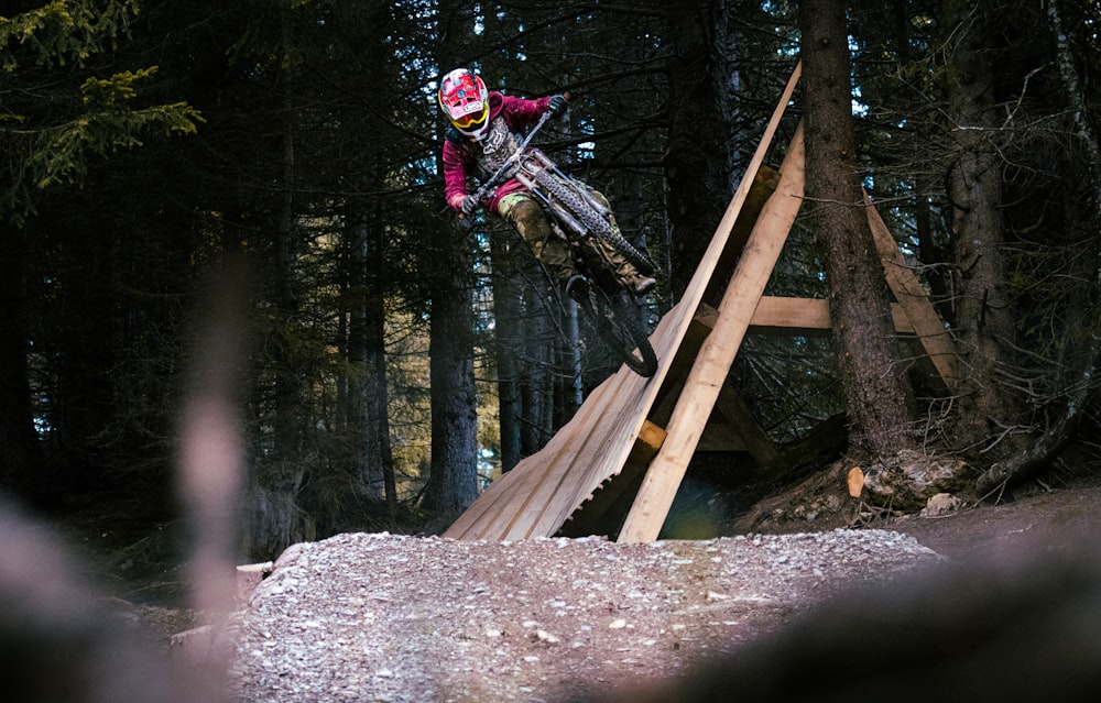 man riding motocross dirt bike on brown wooden bridge