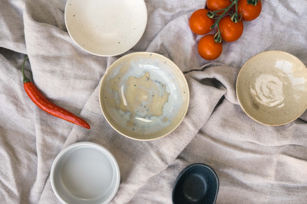 white ceramic round plate on white textile