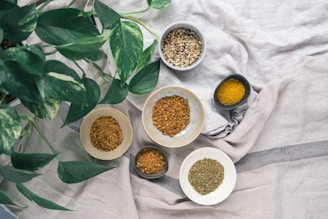 ciotoline di ceramica con botaniche e spezie su una tovaglia di cotone
