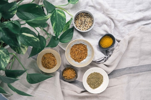 ciotoline di ceramica con botaniche e spezie su una tovaglia di cotone