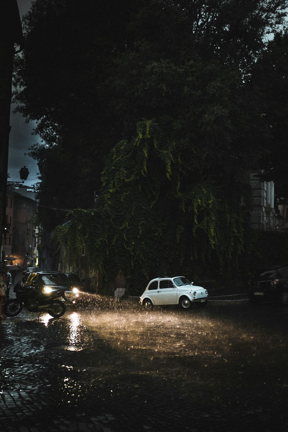 white crew cab pickup truck parked beside black car during night time