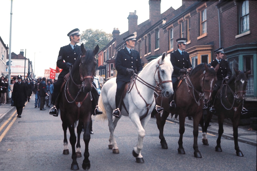 2 men riding horses on street during daytime