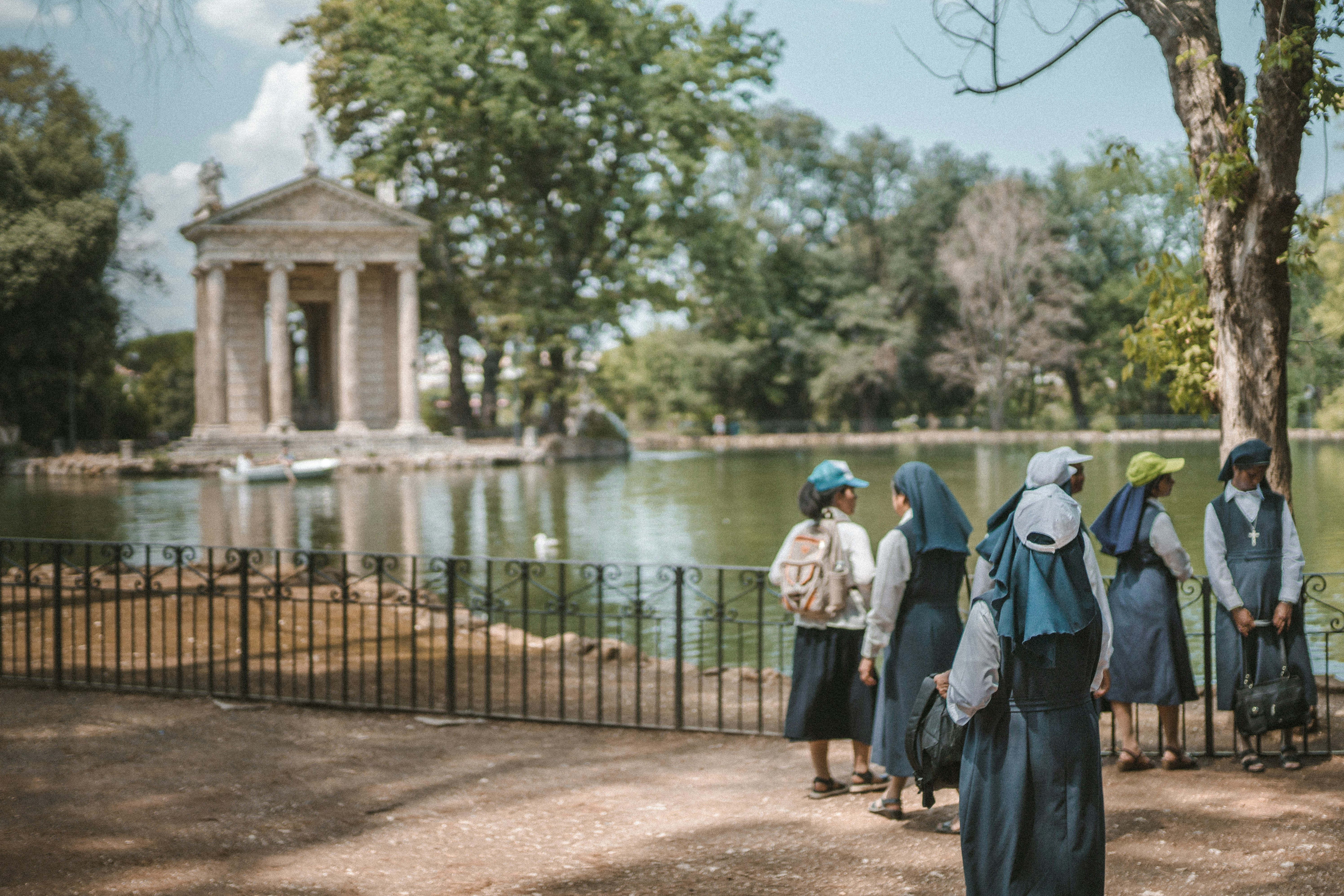 people walking on sidewalk near body of water during daytime