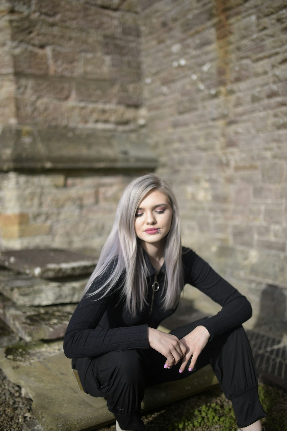 woman in black long sleeve shirt sitting on gray concrete bench