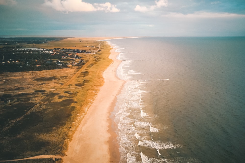 brown sand near body of water during daytime