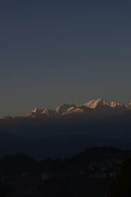 Snow-capped peaks glowing golden at sunset above a quiet mountain village.