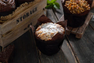 A happy customer enjoying a muffin with a bright smile in a cozy kitchen setting.
