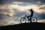 silhouette of person riding on bicycle during daytime