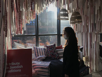 A happy customer wearing a colorful therian mask in a bright, clean room.