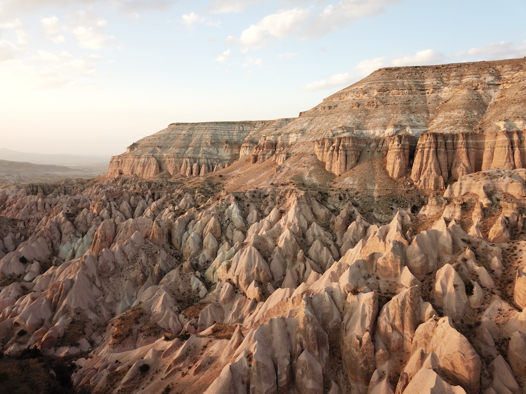 brown rocky mountain under white clouds during daytime, A Sunset shot from red valley Cappadocia, Turkey<p></figure>