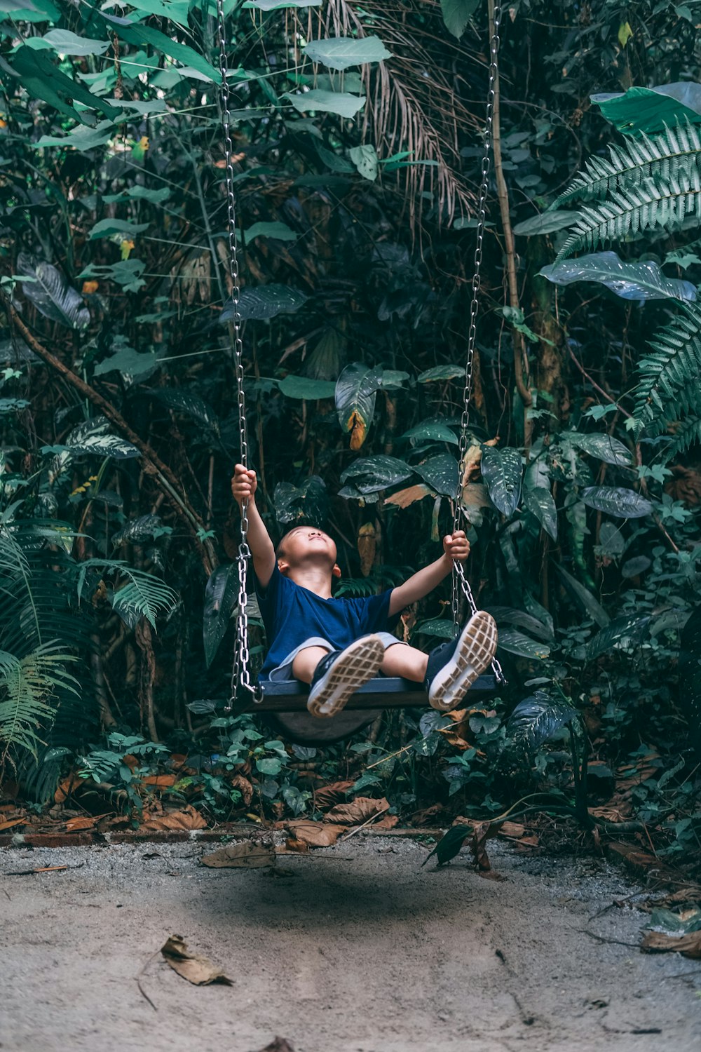 woman in blue shirt and blue denim jeans sitting on swing chair