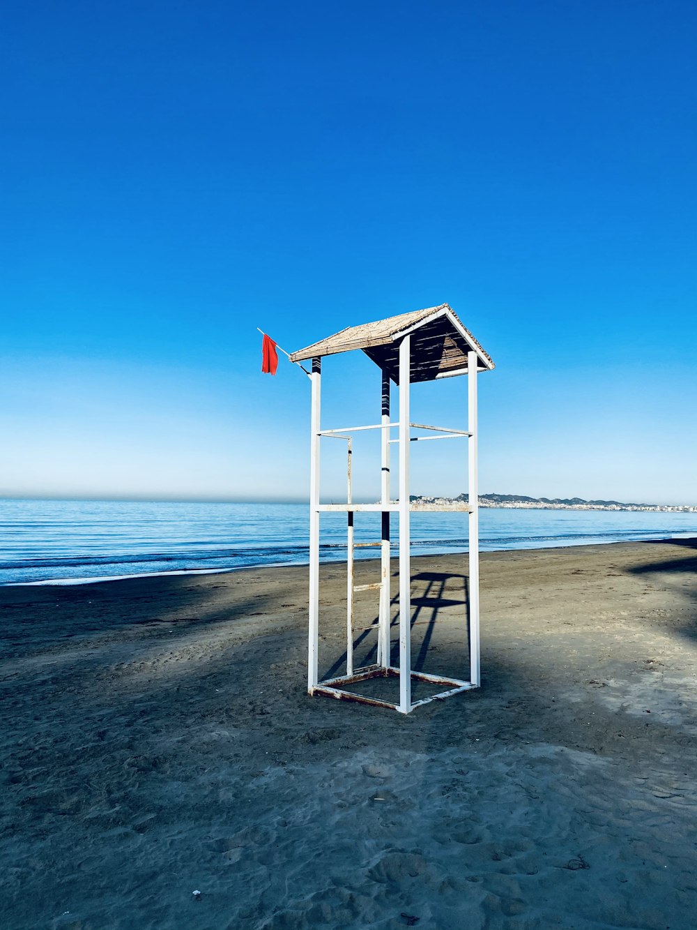 white wooden lifeguard tower on beach during daytime