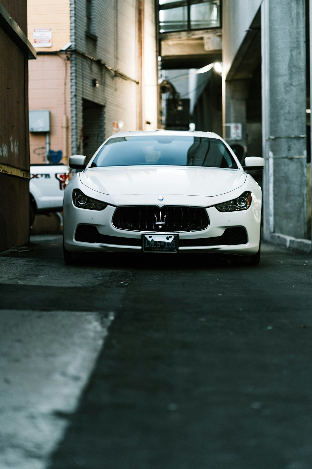 white bmw m 3 parked on sidewalk during daytime