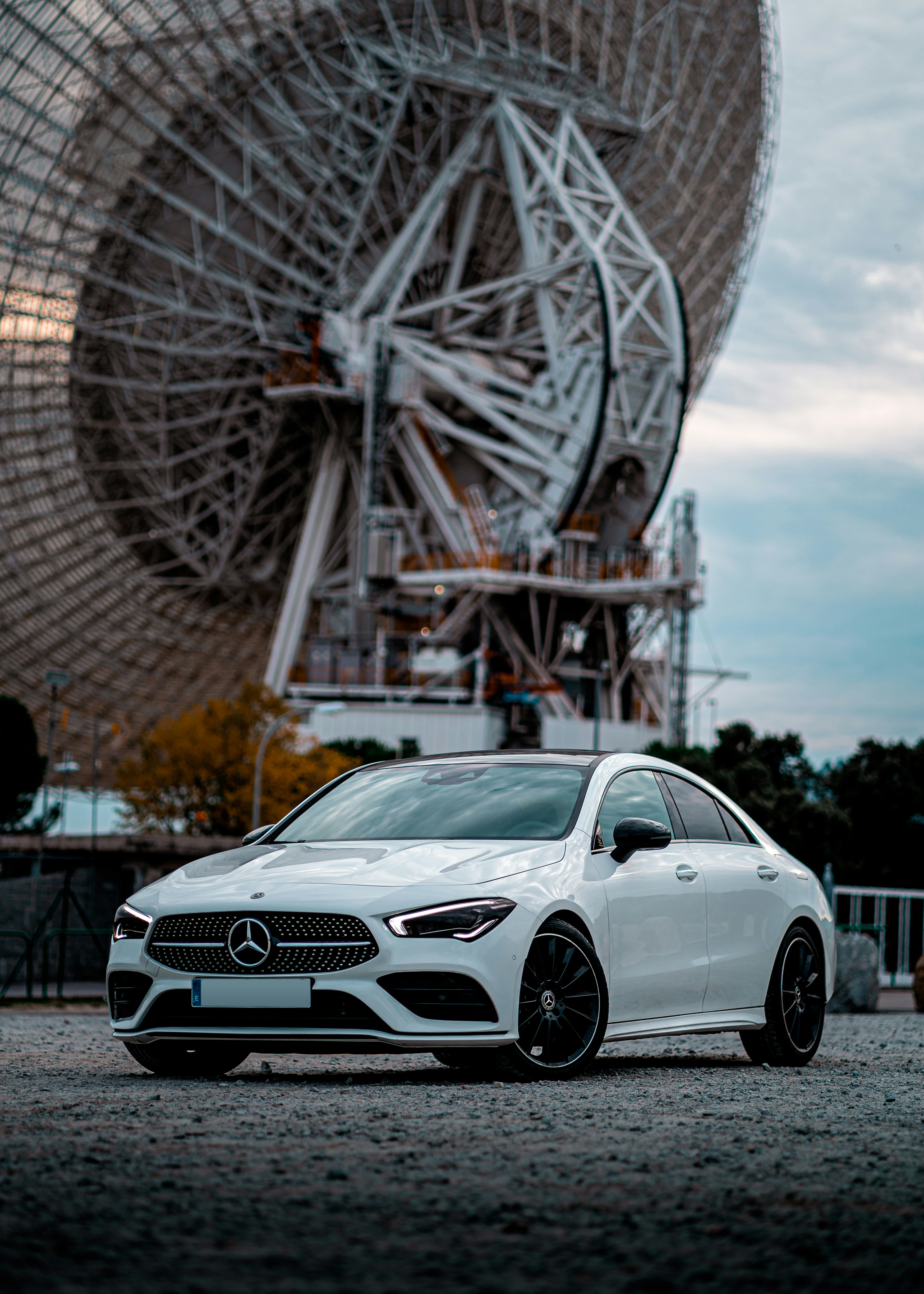 Weißes Mercedes Benz Coupé tagsüber in der Nähe des Riesenrads geparkt