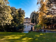 Exterior shot of St Marnock's Fowlis church surrounded by lush greenery under a clear blue sky.