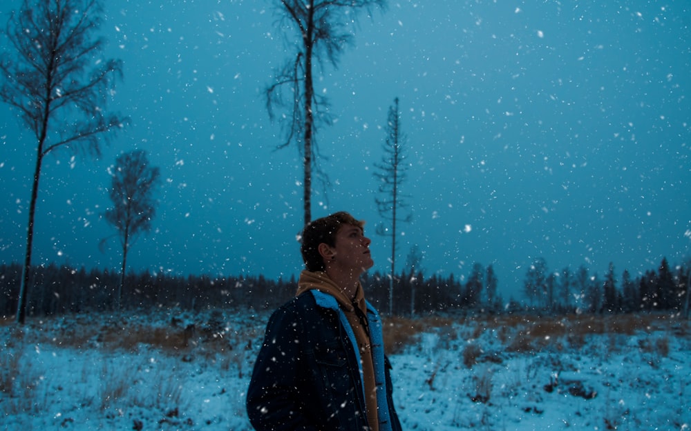 man in black jacket standing near tree during daytime