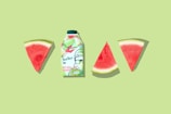 green and white labeled bottle beside sliced watermelon