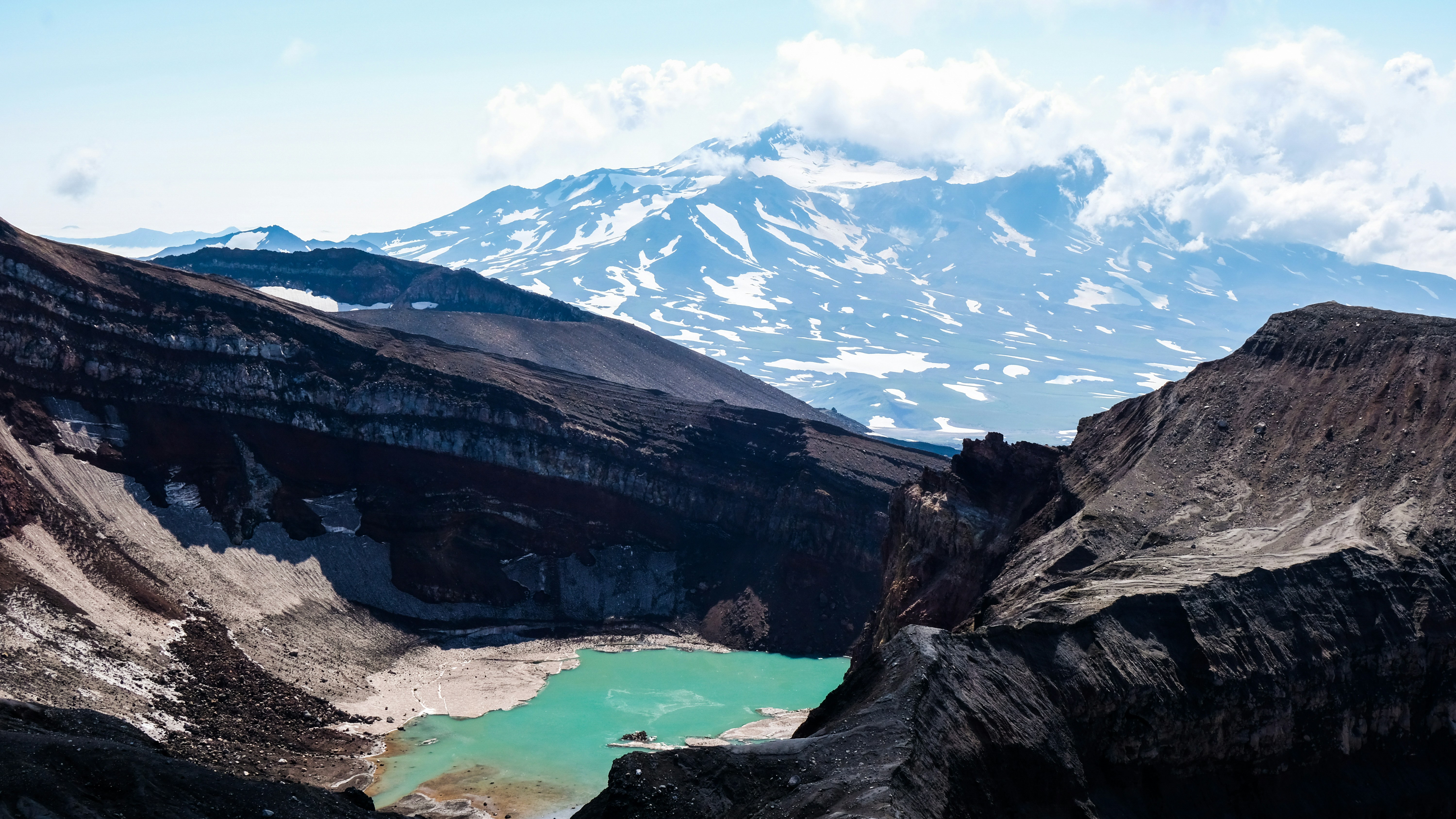 brown rocky mountain near lake under blue sky during daytime