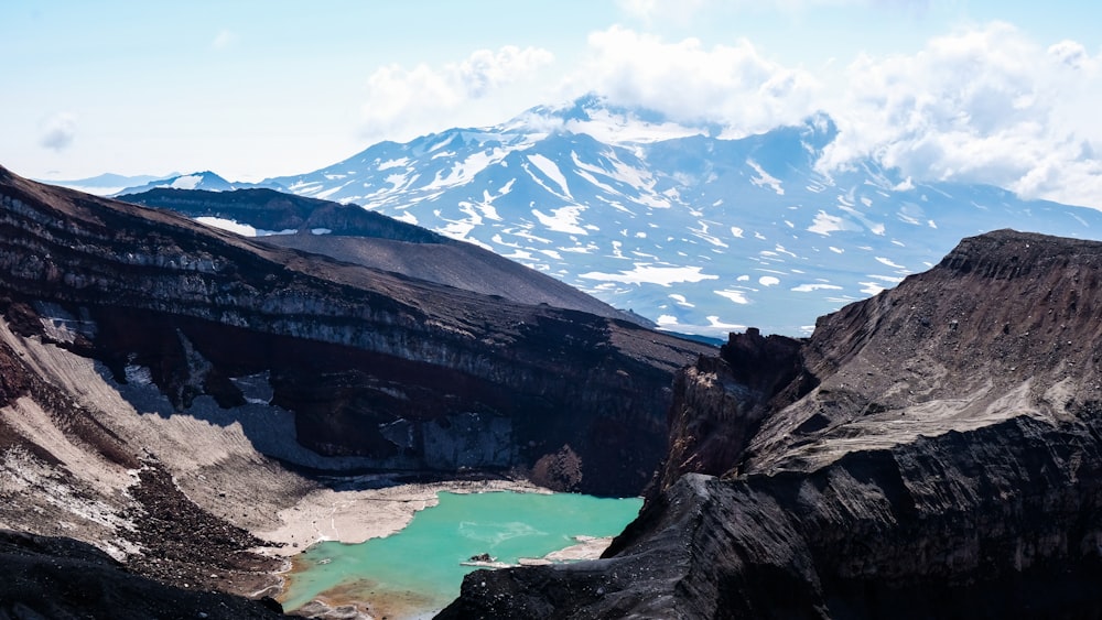 brown rocky mountain near lake under blue sky during daytime