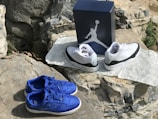 A pair of windkicks sneakers displayed on a rocky outdoor surface.