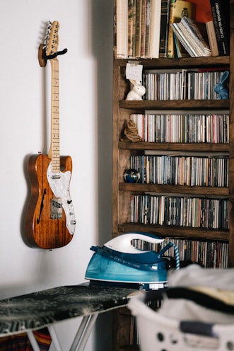 brown and white electric guitar on brown wooden shelf