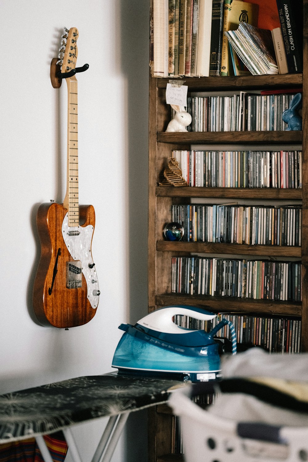 brown and white electric guitar on brown wooden shelf
