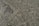 A paved area with cobblestones arranged in a geometric pattern, bordered by a small section of gravel. The arrangement and contrast between the cobblestones and gravel create an interesting visual texture.