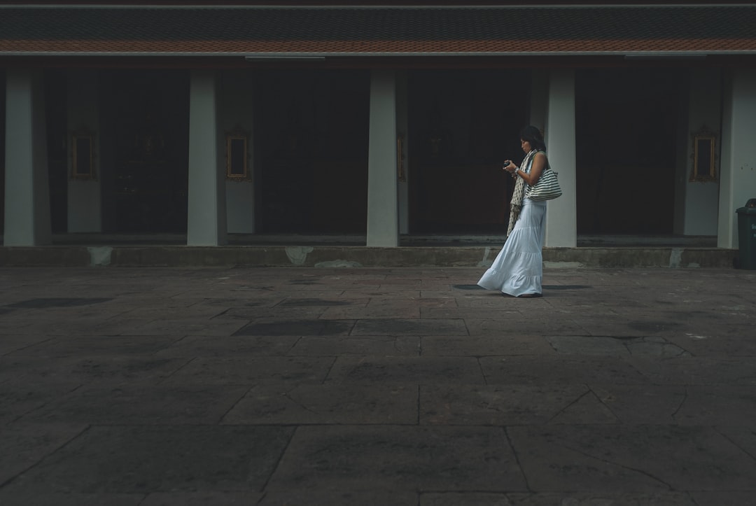 woman in white dress walking on gray concrete floor