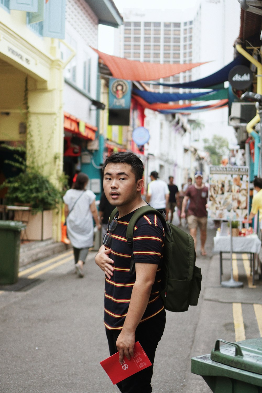 boy in black jacket standing on street during daytime