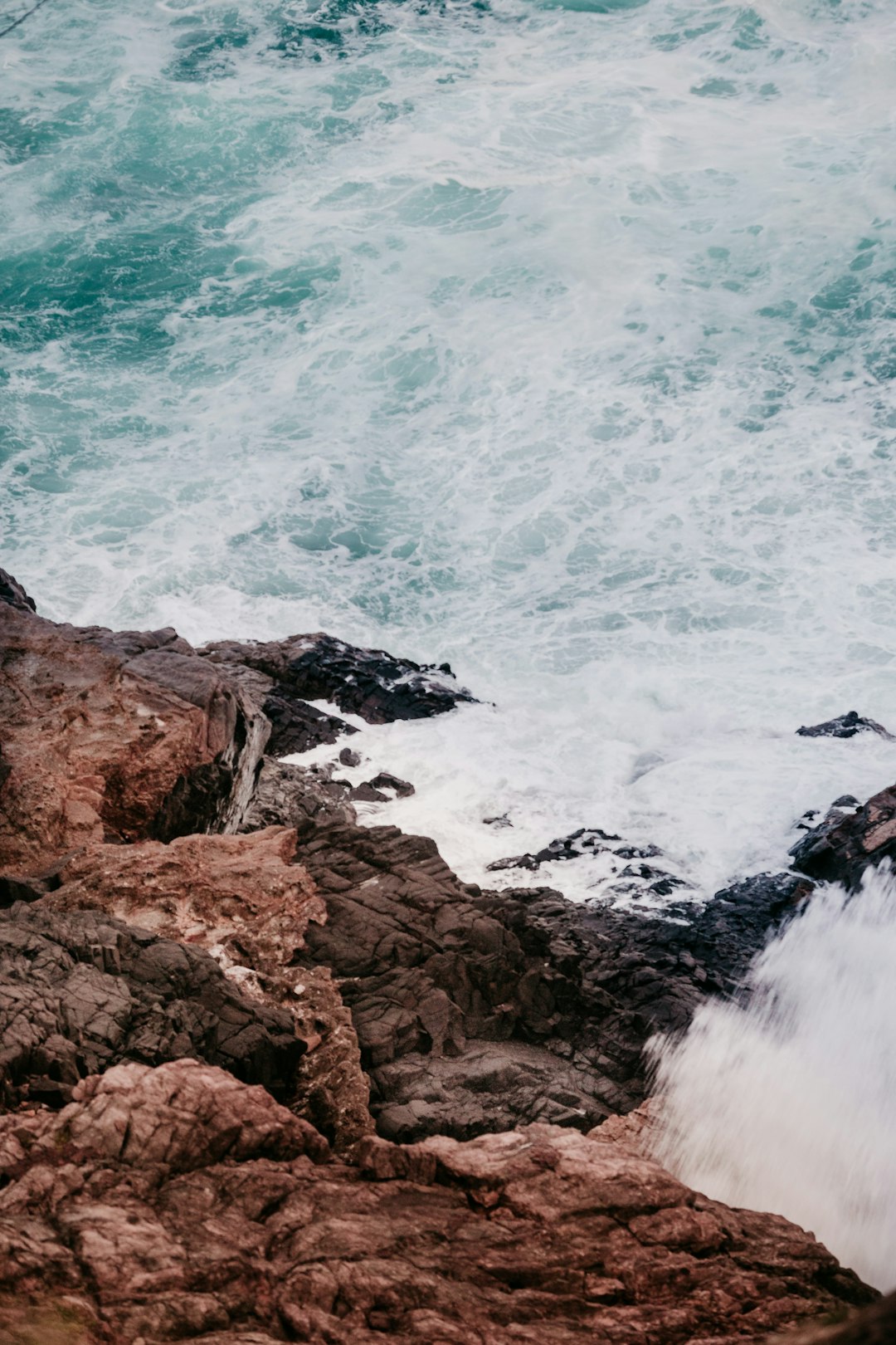 brown rock formation near body of water during daytime