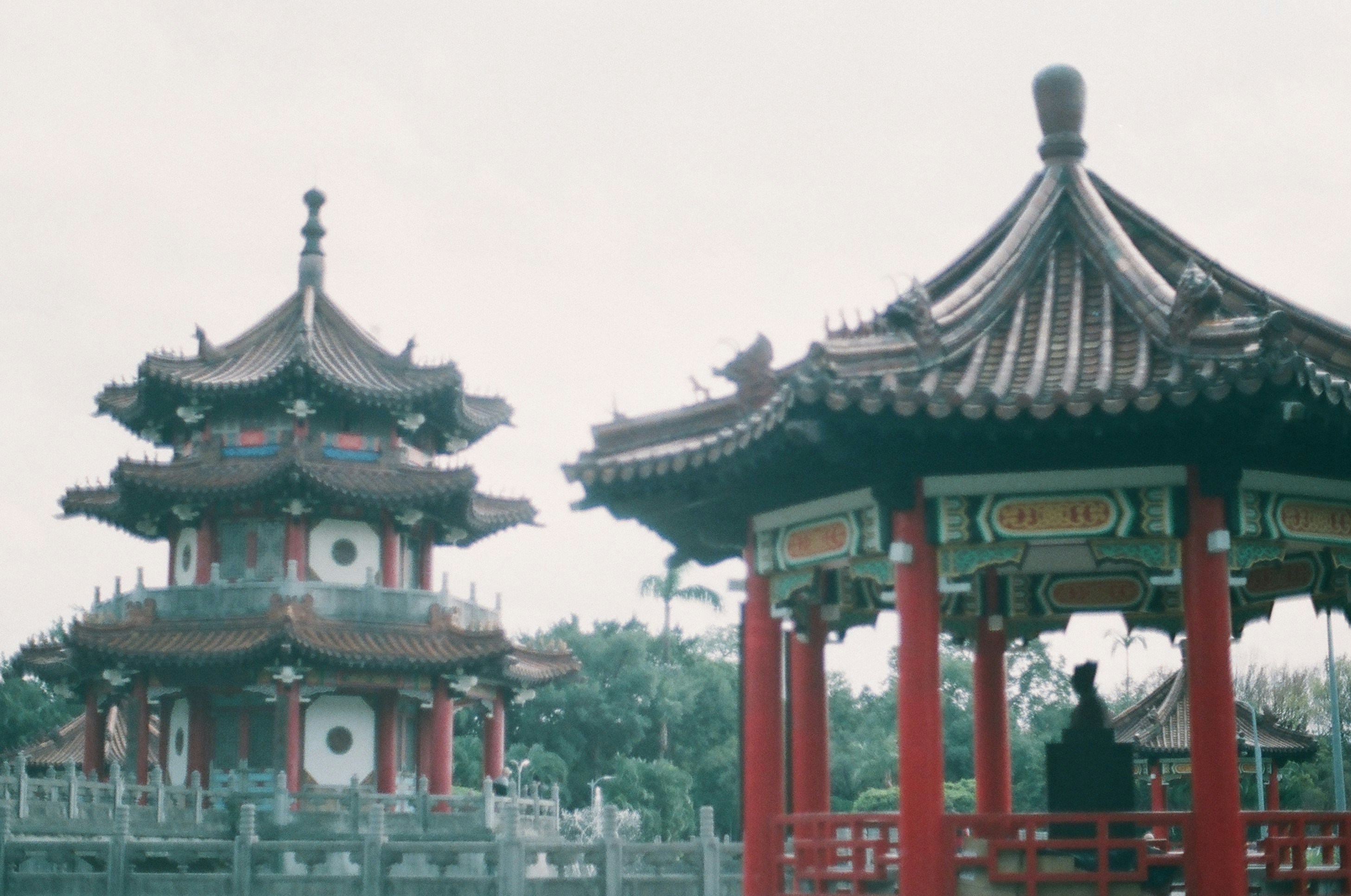 red and black temple near body of water during daytime