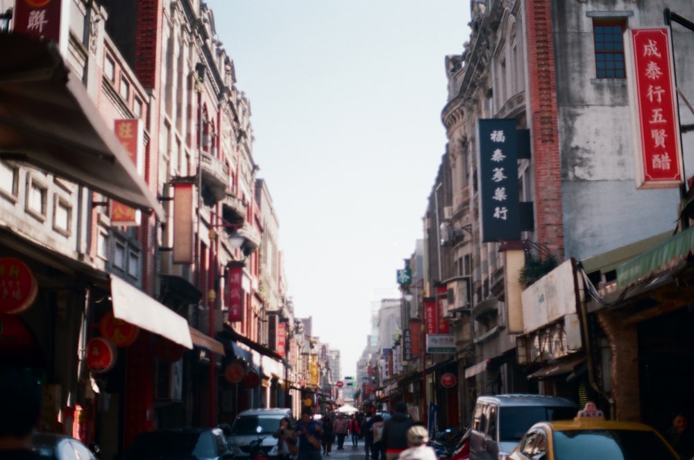 cars parked on street between buildings during daytime