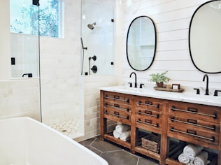 white ceramic bathtub near brown wooden cabinet