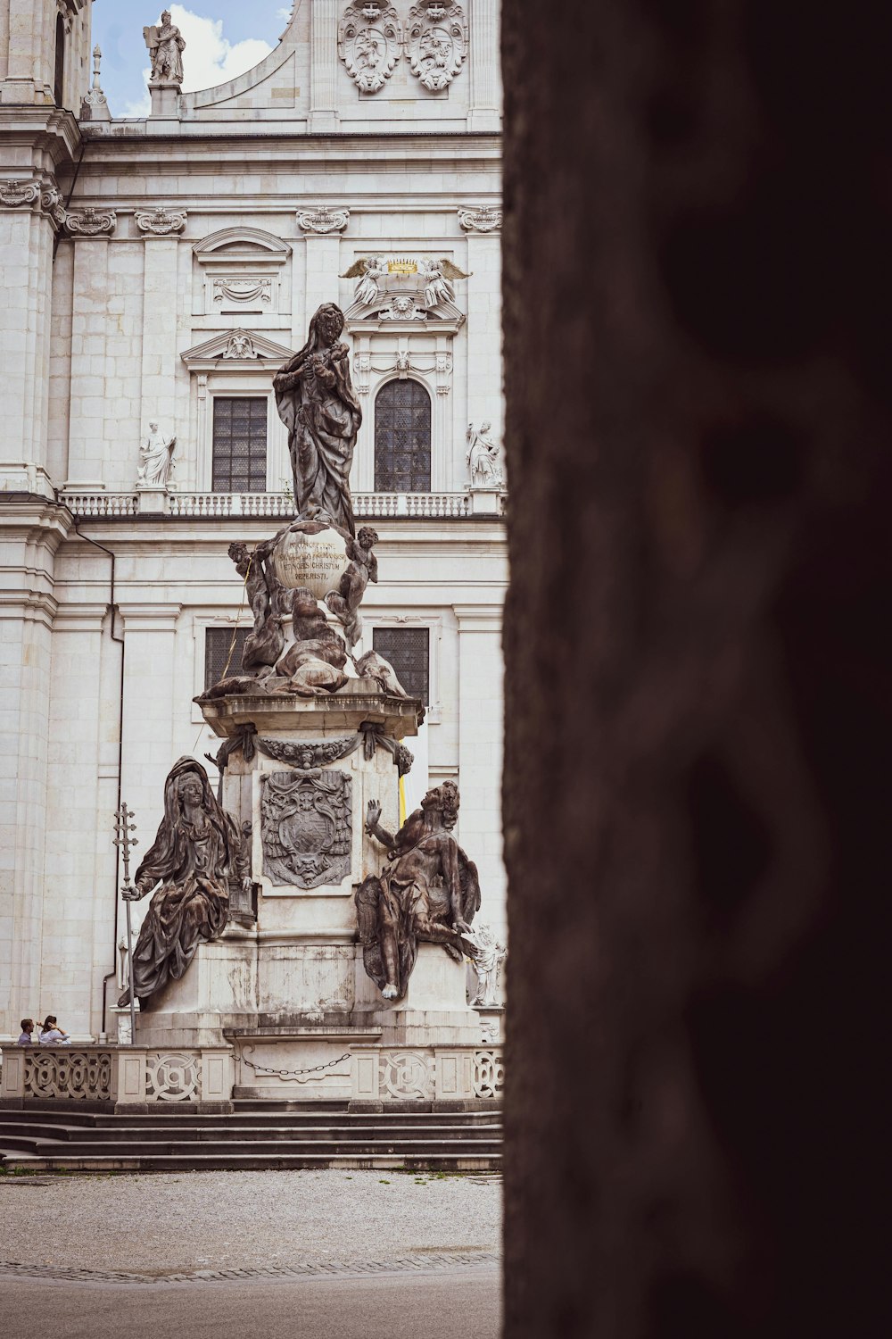 estatua dorada del hombre frente al edificio blanco