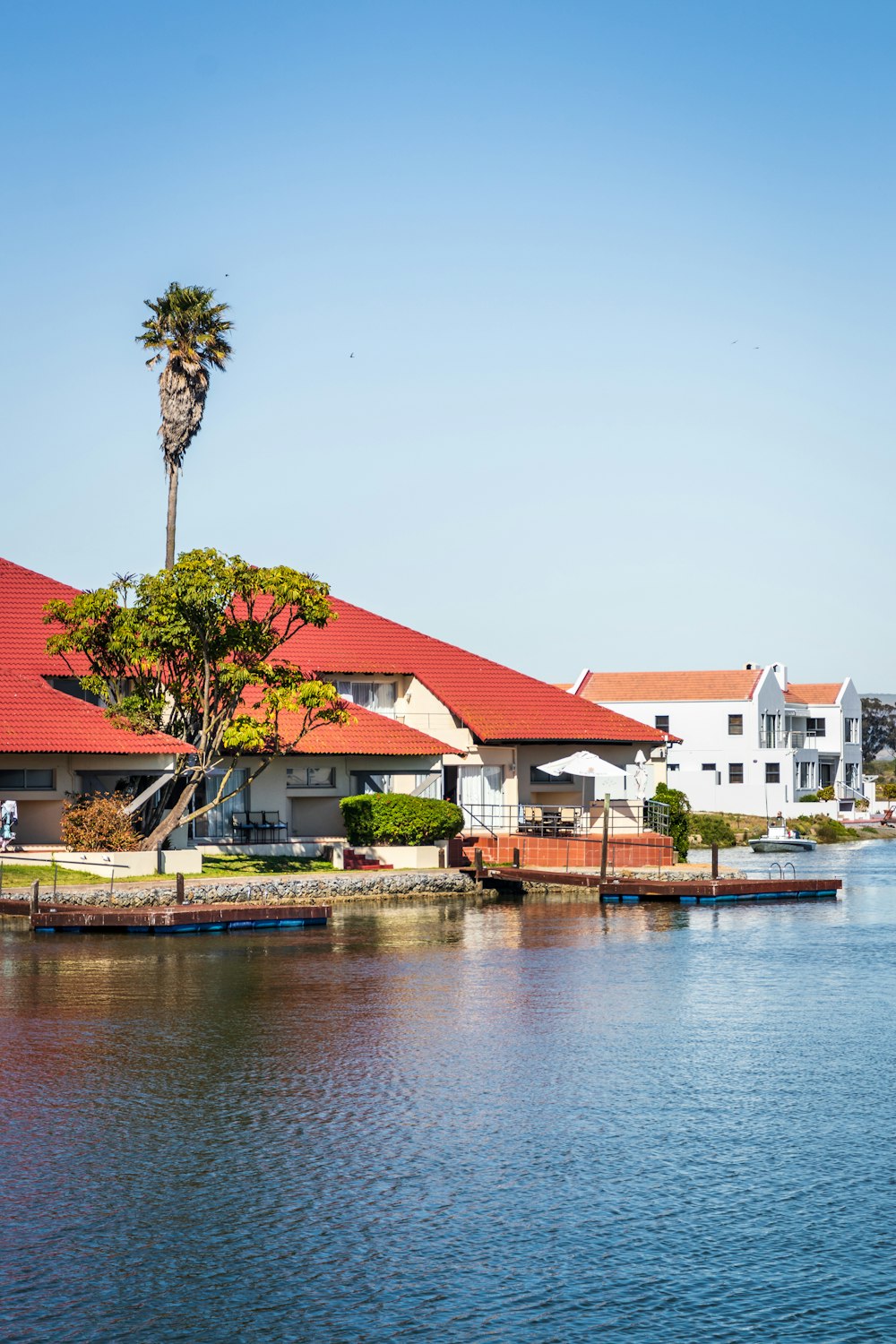 white and red house beside body of water during daytime