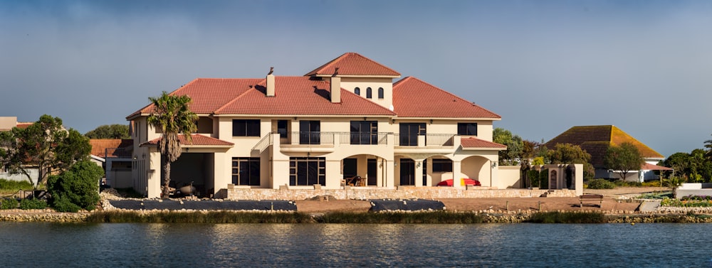 brown and white concrete house beside river during daytime