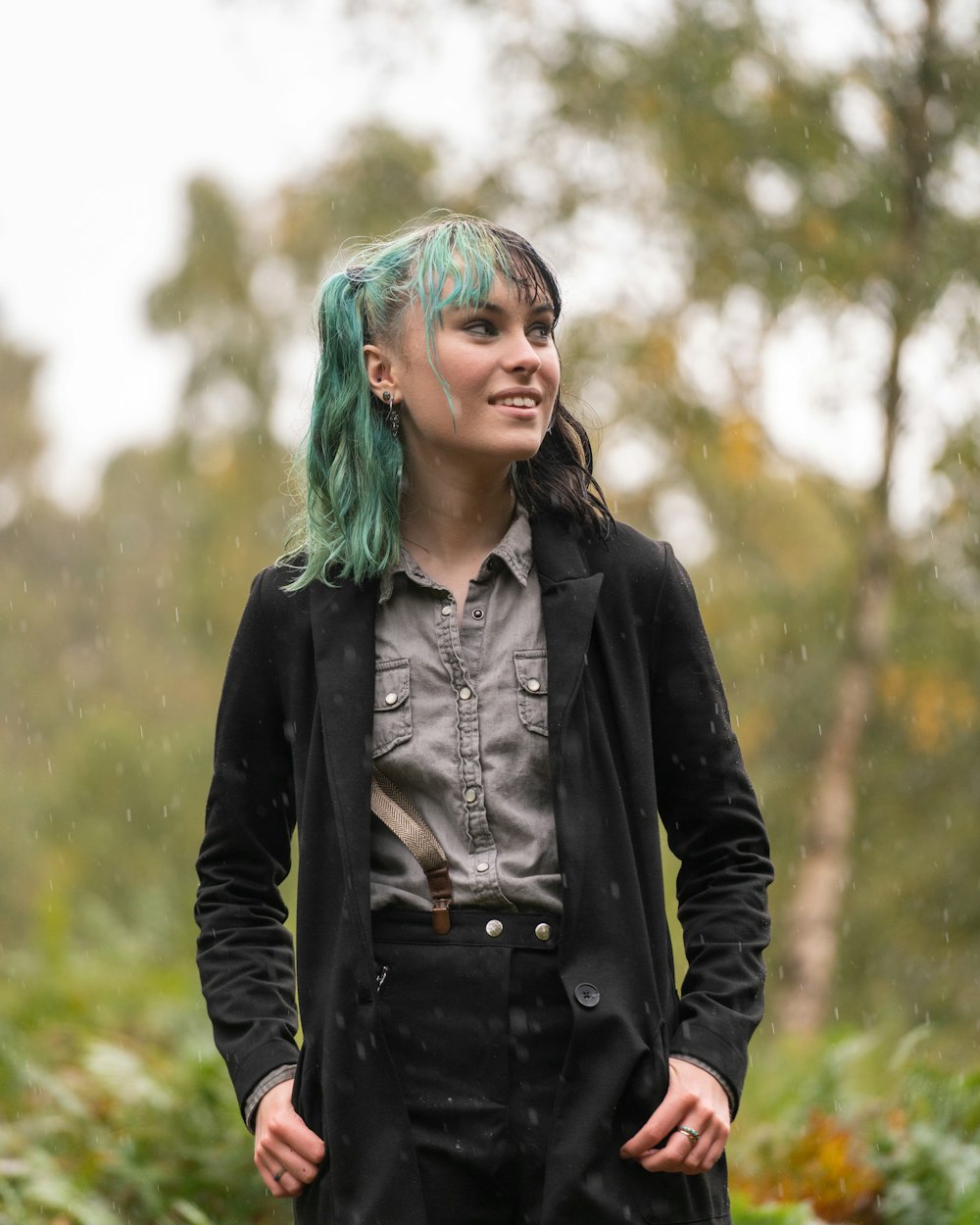 woman in black leather jacket standing on green grass field during daytime
