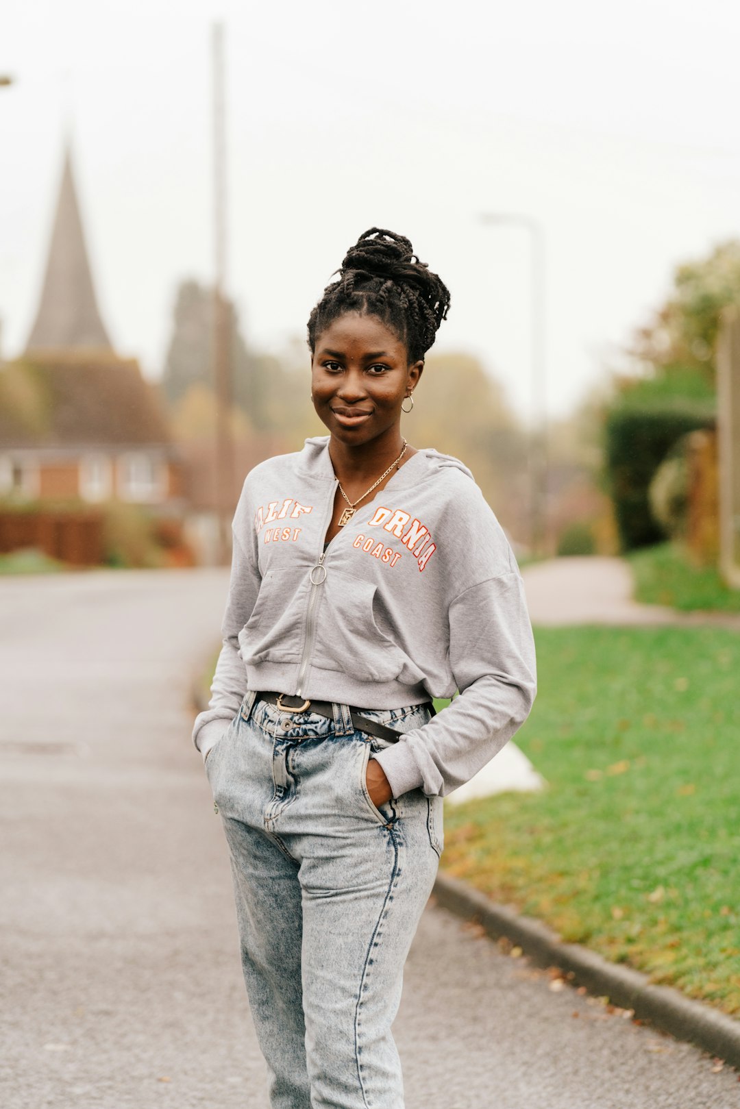 woman in white zip up hoodie standing on road during daytime