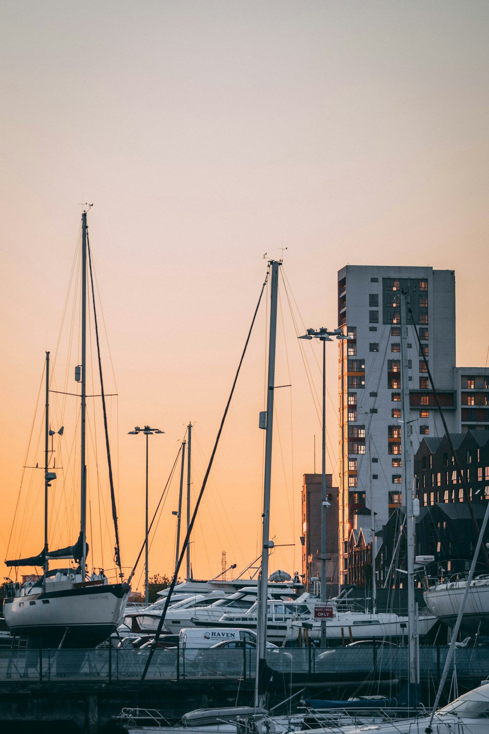 white sail boat on dock near city buildings during daytime