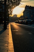 Sunset casting warm light on a freshly paved street.
