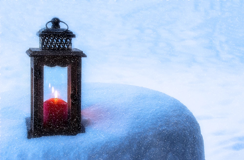 black candle lantern on white snow