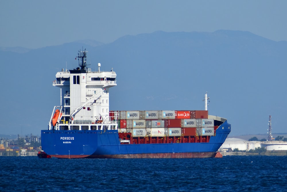 blau-weißes Frachtschiff tagsüber auf See