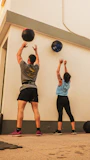 man in gray shirt and black shorts holding blue ball