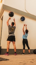 man in gray shirt and black shorts holding blue ball
